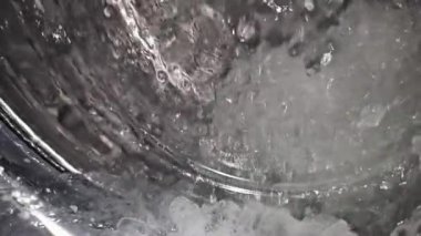 Çamaşır makinesine su sıçratan süper yavaş çekim, cep telefonuyla yapılan videodaki ağır ara polasyon objeleri.