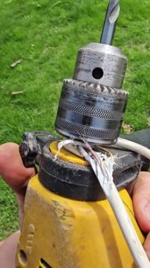 Kablo eski sarı el yapımı bir matkabın etrafına dolanmış ve hasar görmüş.