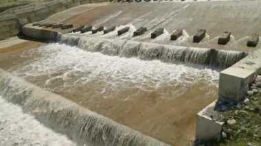 Bir sıra paraşüt, beton su sızıntısı kanalındaki blokları dengeleyerek suyun akışını yavaşlatır..