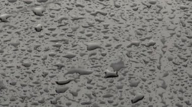 Siyah araba kaput yüzeyine yağmur damlaları düşer, yavaş çekimde yaklaşır