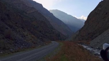 siyah dijital profesyonel tam kare aynasız kamera tripodla akşam dağ geçidini yol ve küçük nehir ile vuruyor, dönüyor ve dönüyor.