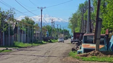 Kırgızistan, Bişkek yakınlarındaki Gavrilovka köyünde kırsal kesimde eski kamyonlar ve ara sıra trafik - 2 Mayıs 2024