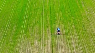 tarımsal traktör yeşil alana kimyasallar püskürtüyor, tam çerçeve hava yüksek açı görüntüsü