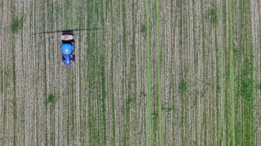 tarımsal traktör yeşil alana kimyasallar püskürtüyor, tam çerçeve hava yüksek açı görüntüsü