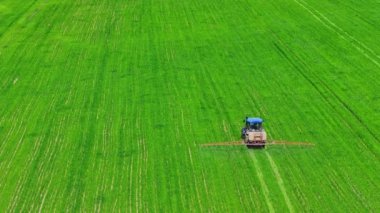 tarımsal traktör yeşil alana kimyasallar püskürtüyor, tam çerçeve hava yüksek açı görüntüsü