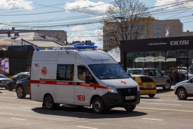 Rusya 'nın Tula şehrinde güneşli bir günde şehir caddesi boyunca giden beyaz ambulans minibüsü - 7 Haziran 2021