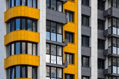 Taze inşa edilmiş, gri-sarı, yüksek katlı apartman dairesi, tam kare yakın plan..