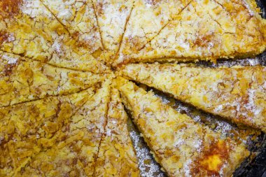 Yerel elmalı turta, siyah yuvarlak dökme demir tavayla dilimlenmiş, yakın plan.