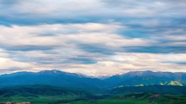 Fırtına bulutları dağ sırasının üzerinde ve akşam yeşil tepeler, insansız hava aracı aşırı hızlanıyor.