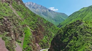 Bereketli yeşil dağ yamaçlarıyla çevrili Manzaralı Dağ Yolu güneşli yaz gününde Vadiden akan bir nehirle