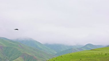 Çiseleyen yaz gününde sisli yeşil dağların üzerinde uçan kuadkopter drone..