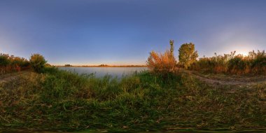Güzel sonbahar günbatımında, kırsal kesimde, dikdörtgen şeklinde yansıtılan küçük gölet kıyılarından oluşan küresel bir manzara.