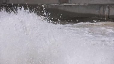 Su beton bir kanala sıçrıyor, yavaş çekim seçici bir odak ile yakın çekim