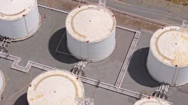 Çoklu silindirik tankları, boru hatları ve altyapısı olan büyük bir endüstriyel yakıt depolama tesisinin insansız hava aracı görüntüleri. Petrol ürünleri ve yakıt dağıtımının depolanması.