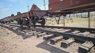 Sokuluk, Kırgızistan 'da güneşli bir yaz gününde eski eğimli tren raylarında eski ahşap yataklı bölümde hareket eden trenin yakın görüntüsü - 3 Temmuz 2024