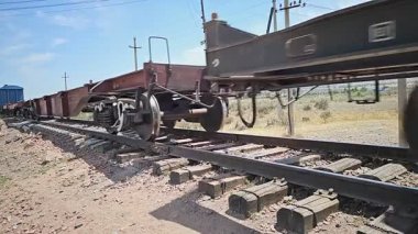 Sokuluk, Kırgızistan 'da güneşli bir yaz gününde eski eğimli tren raylarında eski ahşap yataklı bölümde hareket eden trenin yakın görüntüsü - 3 Temmuz 2024