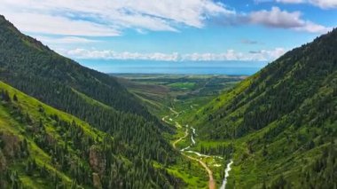 Mavi gökyüzünde beyaz bulutlu yeşil dağ yamaçları, drone hiperlapse