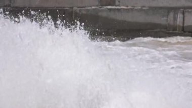 Su beton bir kanala sıçrıyor, yavaş çekim seçici bir odak ile yakın çekim