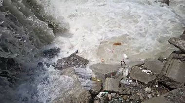 Plastik şişeler, Şelale Kıyısında Şelale Şelalesi 'nde kapana kısılmış. Cep telefonu yavaş çekim.