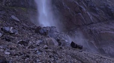 Su şelalenin eteğindeki kayalara çarpar, yavaş çekim, yukarı doğru çıkar.