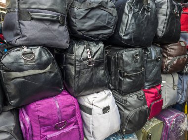 Asya pazarında indirimde olan ucuz çantalardan oluşan duvar, yakın plan.