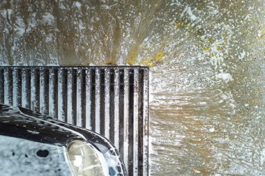 Sabun atıkları araba yıkama garajında zemin drenaj şebekesine akıyor, yüksek açılı yakın çekim..