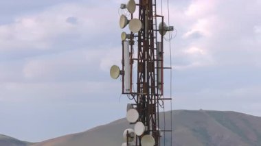 Ufukta bulutlu gökyüzü ve dağların önündeki telekomünikasyon kulesi, yakın çekim
