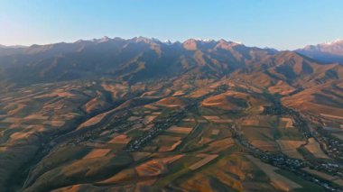 Dağ vadisinin hava aracı görüntüleri, günbatımındaki tarlalar, aşağı doğru kayan kameralar..