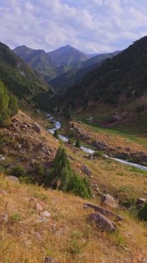 Güz Dağı Vadisi 'nin el kameralı görüntüsü, kayalık arazi, kuru çimler, yeşil tepeler, bulutlu gökyüzü.,