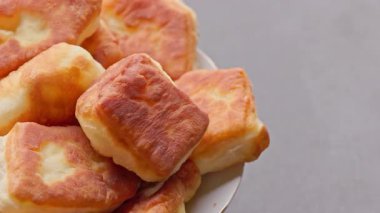 Pikapta dönen ev yapımı kızarmış turtalar, seçici odaklanma, döngüsel görüntüler. Altın-kahverengi kabuk, yumuşak iç döşeme, insan yok, gri nötr arka plan.