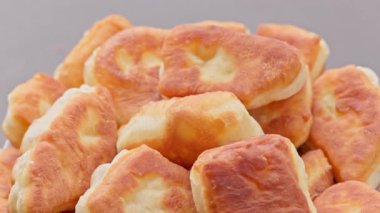 Pikapta dönen ev yapımı kızarmış turtalar, seçici odaklanma, döngüsel görüntüler. Altın-kahverengi kabuk, yumuşak iç döşeme, insan yok, gri nötr arka plan.