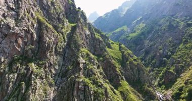 Kırgızistan 'ın Tian Shan dağlarındaki dar kayalık vadi boyunca havadan çekilen görüntüler. Açık hava ve engebeli arazi.