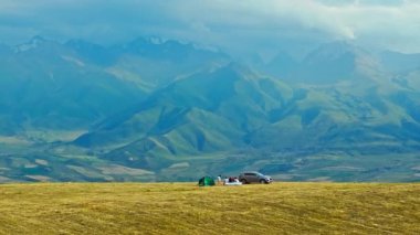 Kırgızistan, Bişkek 'te 3 Ağustos 2024' te bulutlu bir sonbahar gününde tepenin üstünde aile pikniği manzarası ve arka planda dağlar.