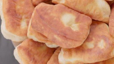 Pikapta dönen ev yapımı kızarmış turtalar, seçici odaklanma, döngüsel görüntüler. Altın-kahverengi kabuk, yumuşak iç döşeme, insan yok, gri nötr arka plan.