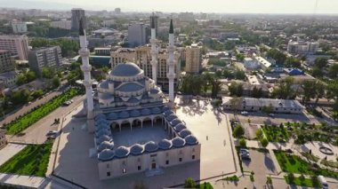 2024 yazında Kırgızistan 'ın Bişkek kentindeki Türk Camii olarak da bilinen Bişkek Merkez Camii' nin hava görüntüleri. İslami mimari, minareler ve çevre kentsel alan. Yörünge kamerası hareketi.