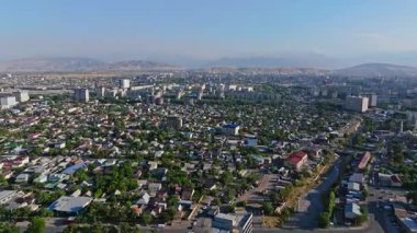 2024 yazında Bishkek, Kırgızistan 'daki bir yerleşim bölgesinin hava kulesi görüntüleri. Daire binaları ve dağlık arkaplanı gösteriyor. Kentsel ve kültürel projeler için ideal.