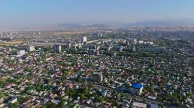 2024 yazında Bishkek, Kırgızistan 'daki bir yerleşim bölgesinin hava görüntüleri. Daire binaları ve dağlık arkaplanı gösteriyor. Kentsel ve kültürel projeler için ideal.