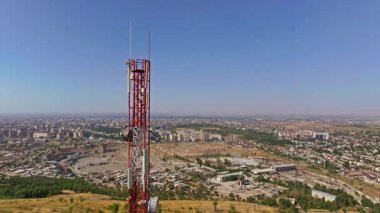 Kırgızistan 'da yaz sonu güneşli yaz gününde Bishkek şehrinin önündeki iletişim kulesi