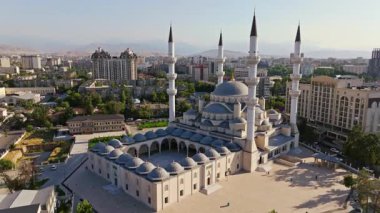 Aerial footage of Bishkek Central Mosque, also known as Turkish Mosque, in Bishkek, Kyrgyzstan during summer 2024. Features Islamic architecture, minarets, and surrounding urban area. Boom upward camera movement.
