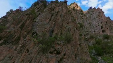 Kırgızistan 'daki kayalık bir yamacın insansız hava aracı görüntüleri. Dokusunu ve ölçeğini yukarı doğru dinamik bir hareketle gösteriyor..