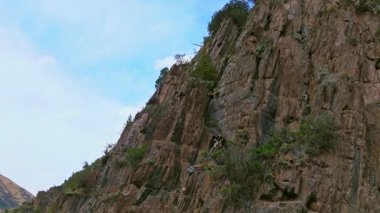 Drone görüntüleri, Kırgızistan 'daki bir dağ vadisinde kayalık bir kayalık kayalık kayayı yakalar. Dokusunu ve derinliğini gözler önüne serer. Kamera hareketini parallax efektiyle büyüterek uzak, el değmemiş manzarayı gösterir..