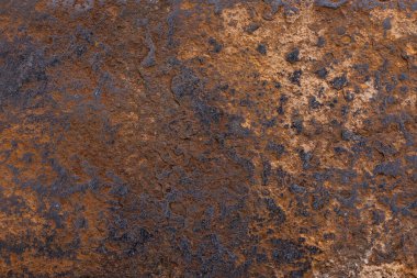 dry heavily rusted orange-colored steel surface texture, close macro view.