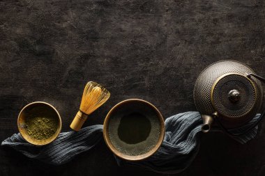 Yeşil kibrit çayı içeceği ve siyah arkaplanda çay aksesuarları.. 