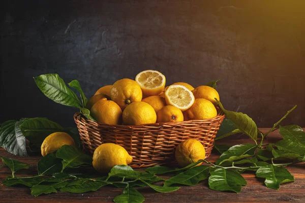 木のテーブルの上に葉を持つバスケットの新鮮なレモン テキストのためのフリースペース — ストック写真