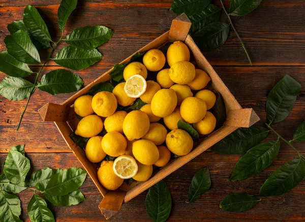 熟したレモンと木の箱の中のカット作品のトップビュー — ストック写真