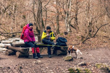 Anne ve oğlu ve köpeği dinleniyor. Sonbahar yürüyüşü