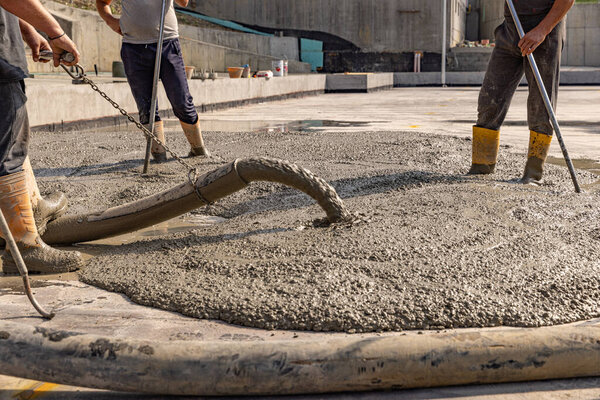Construction worker pouring a wet concret at construction site