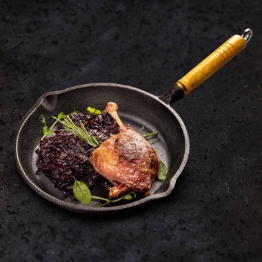 Kırmızı lahana ile servis edilen kızarmış ördek bacağı. 