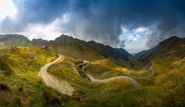 Harika bir dağ manzarası. Fırtınalı gökyüzü olan dağ yolu. Transfagarasan otoyolu, Avrupa ve Romanya 'nın en güzel yolu.