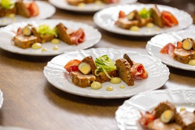 Başlangıç tabakları bir restoranın mutfak tezgahında sıraya dizildi, servis edilmeye hazır..